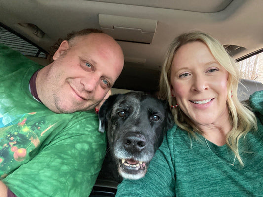 A candid photo of pet parents sitting with their dog in their car - illustrating the everyday connection between them symbolizing companionship and unconditional love - honoring the love and loyalty found in pet companionship