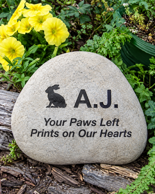 A personalized pet memorial garden stone engraved with a rabbit silhouette, the name 'A.J.