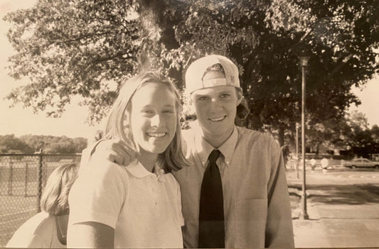 A male and a female high school friends smiling in a black & white photo from the late 1990's