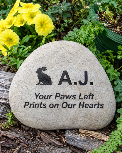A personalized pet memorial garden stone engraved with a rabbit silhouette, the name 'A.J.