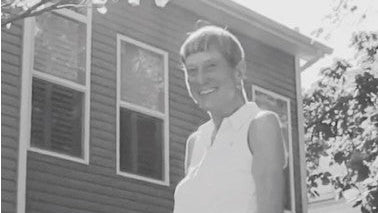 Person standing in front of a house with an Eastern Redbud memorial tree, accompanied by a quote about her meaningful tree gift.